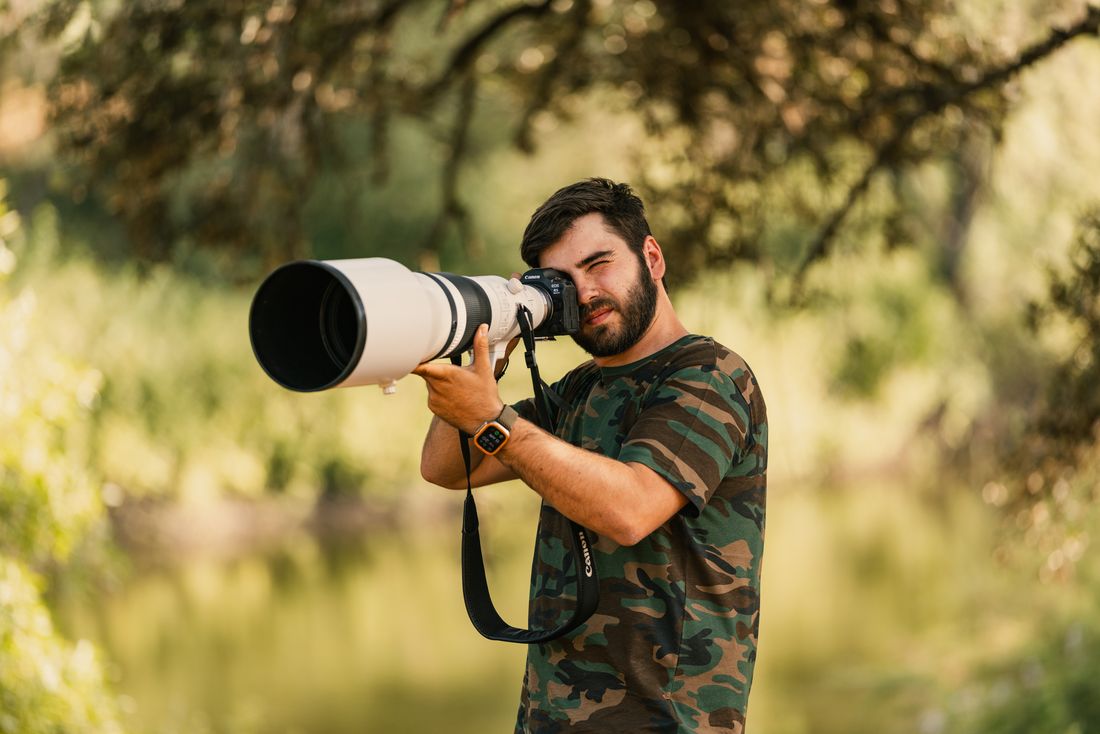 Greg with a telephoto lens in the woods