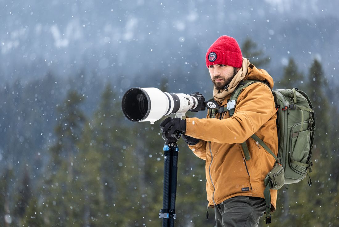 Greg with a Canon super telephoto lens in the snow in Yellowstone